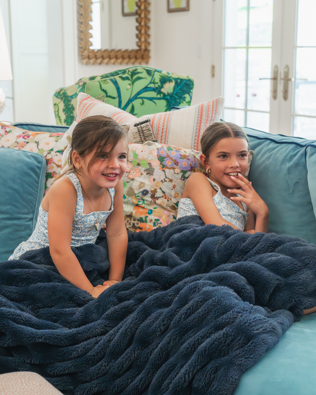 Two little girls giggling on the couch