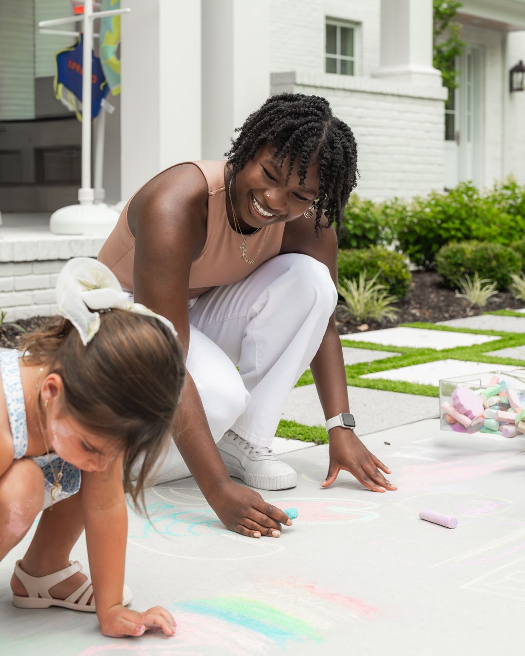 Sitter laughing with a little girl outside